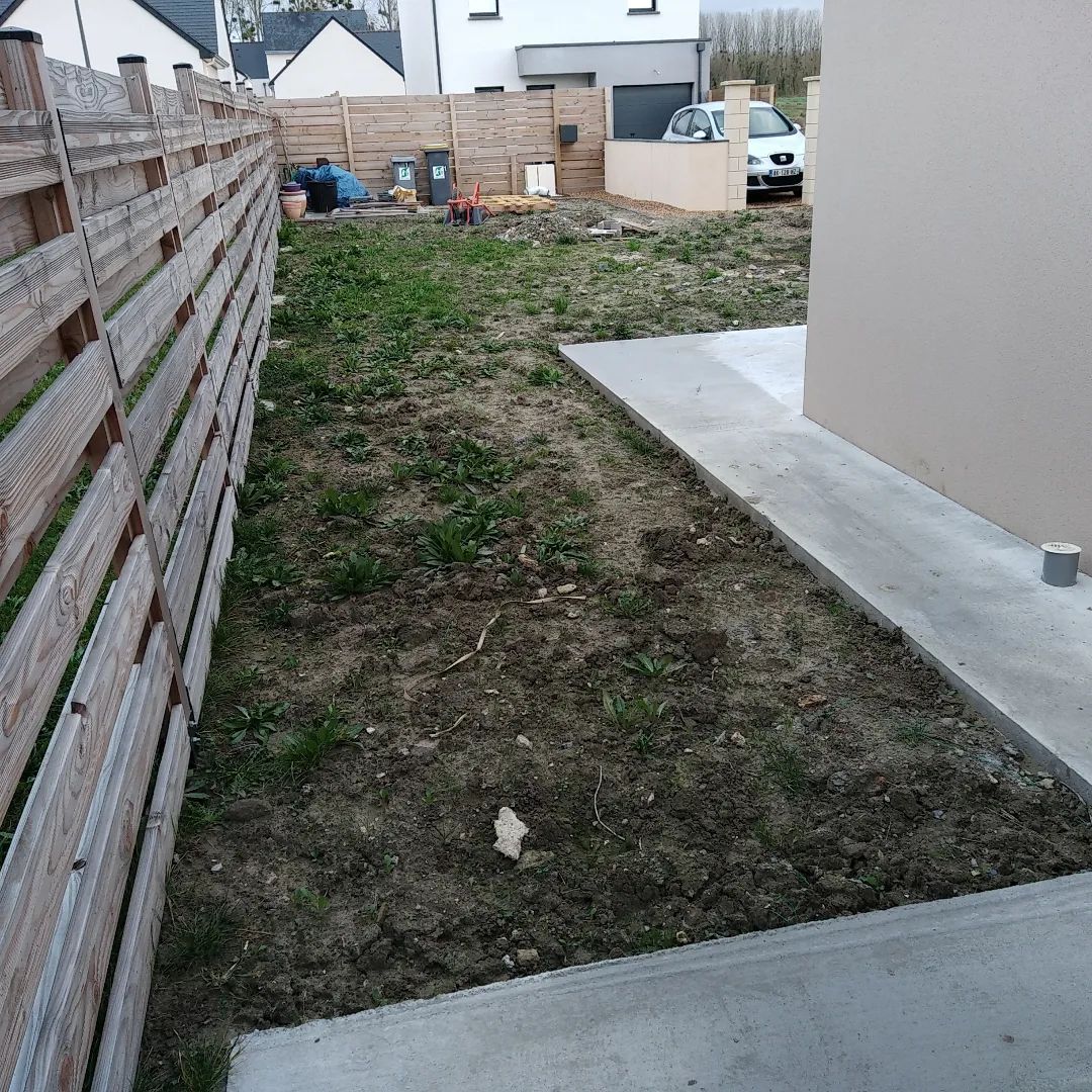 Avant les travaux : terrain nu le long d’une clôture