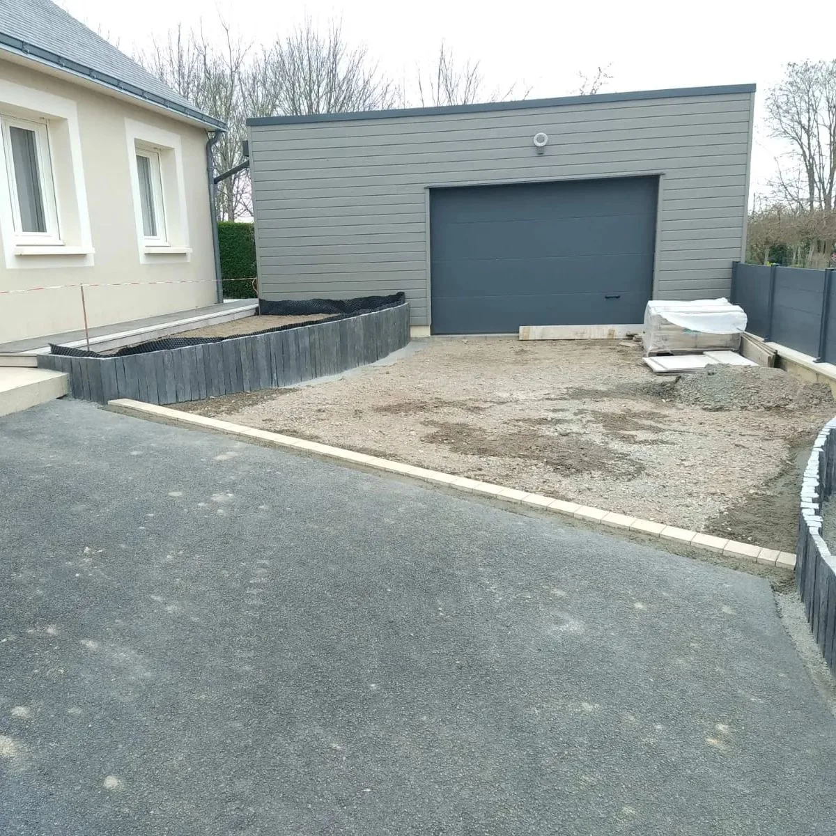 Avant les travaux : sol brut devant un garage