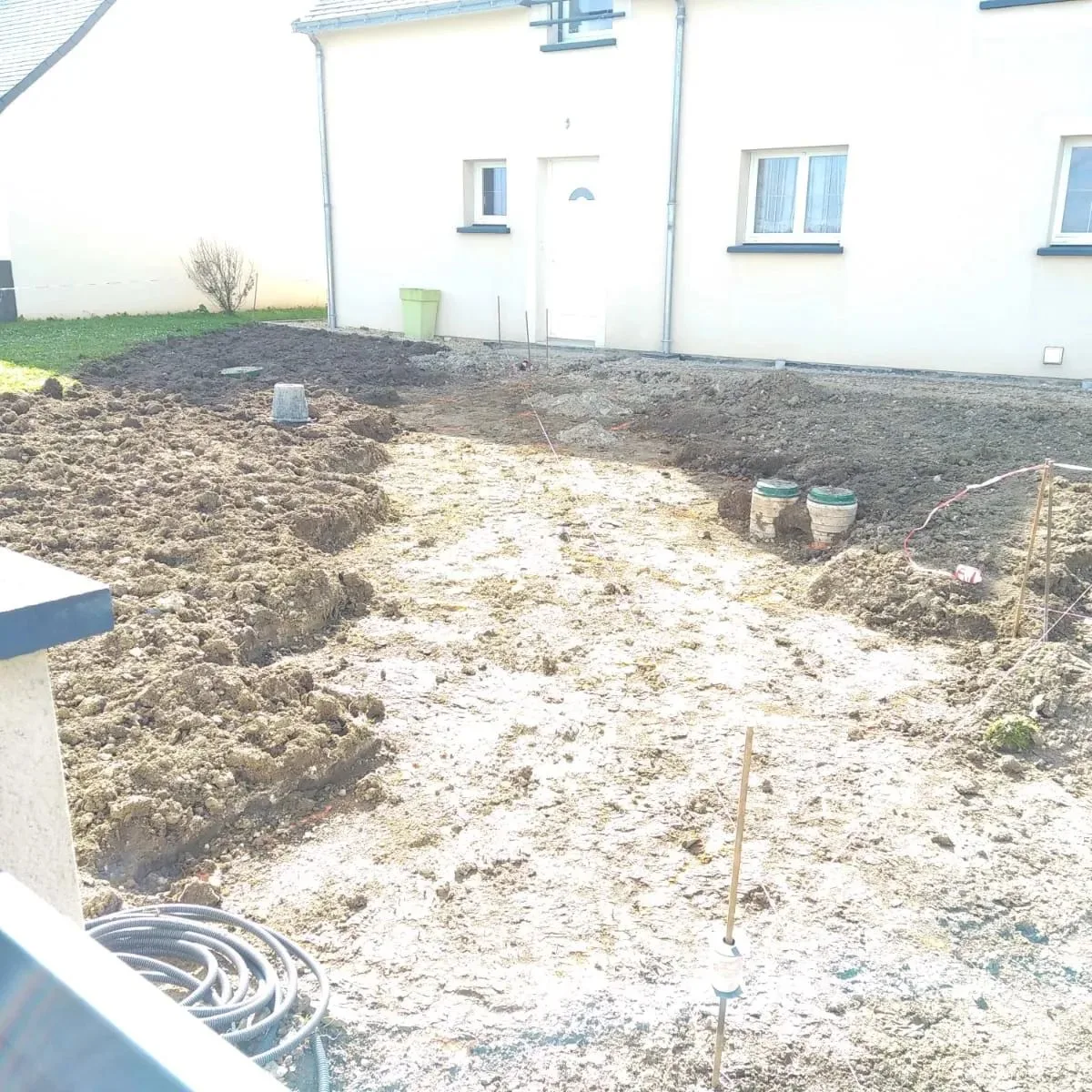 Avant les travaux : terrain en terre devant une maison